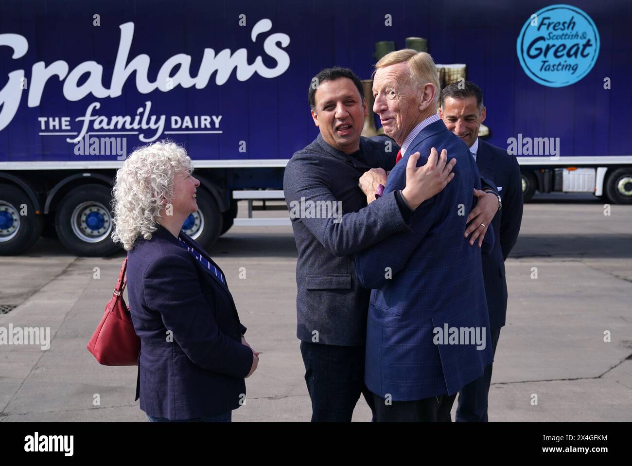 Scottish Labour leader Anas Sarwar embraces Robert Graham snr alongside Robert Graham from Graham's The Family Dairy Dairy during a visit to the dairy in Bridge of Allan. Picture date: Friday May 3, 2024. Stock Photo