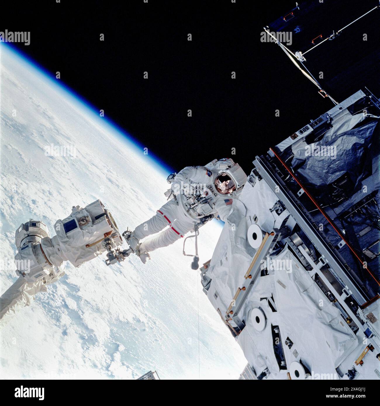 REF: STS110-703-066 ASTRONAUT ROSS, JERRY-L., MISSION SPECIALIST, ANCHORED ON THE END OF THE CANADARM2, MOVES NEAR THE SO (S-ZERO) TRUSS, NEWLY INSTALLED ON THE (ISS) INTERNATIONAL SPACE STATION. Stock Photo