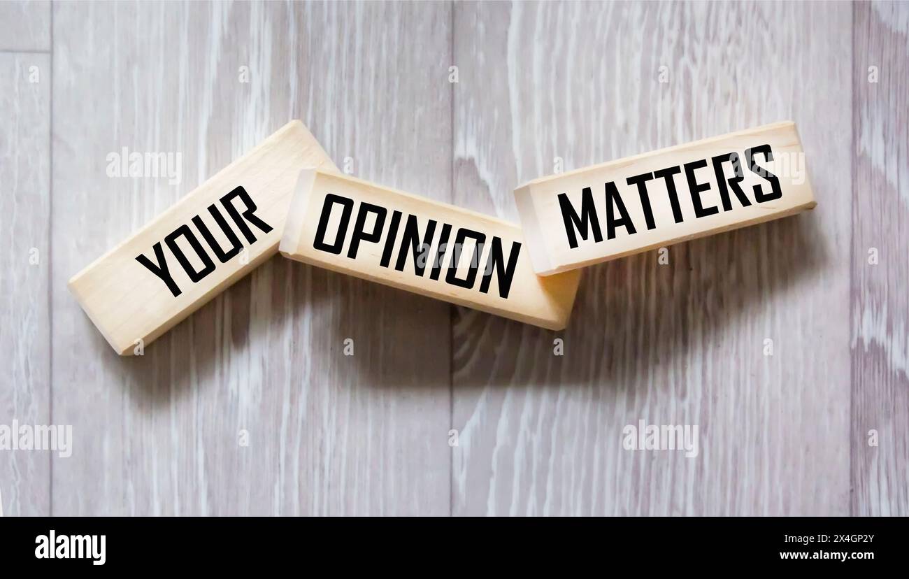 YOUR OPINION MATTERS is written on wooden blocks on a gray background. close-up Stock Photo