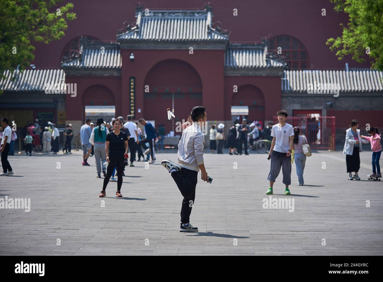 People playing Jianzi, traditional Chinese national sport in which players are kicking shuttlecock in the air in Beijing, China, on 21 April 2024 Stock Photo