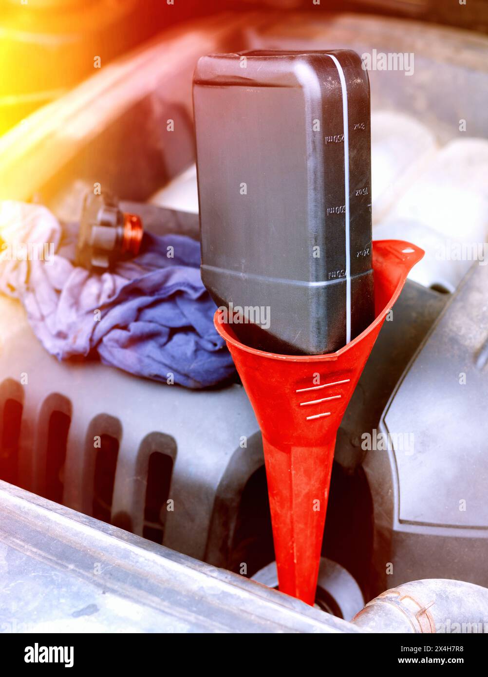 Filling a vehicle's engine with motor oil through a funnel Stock Photo