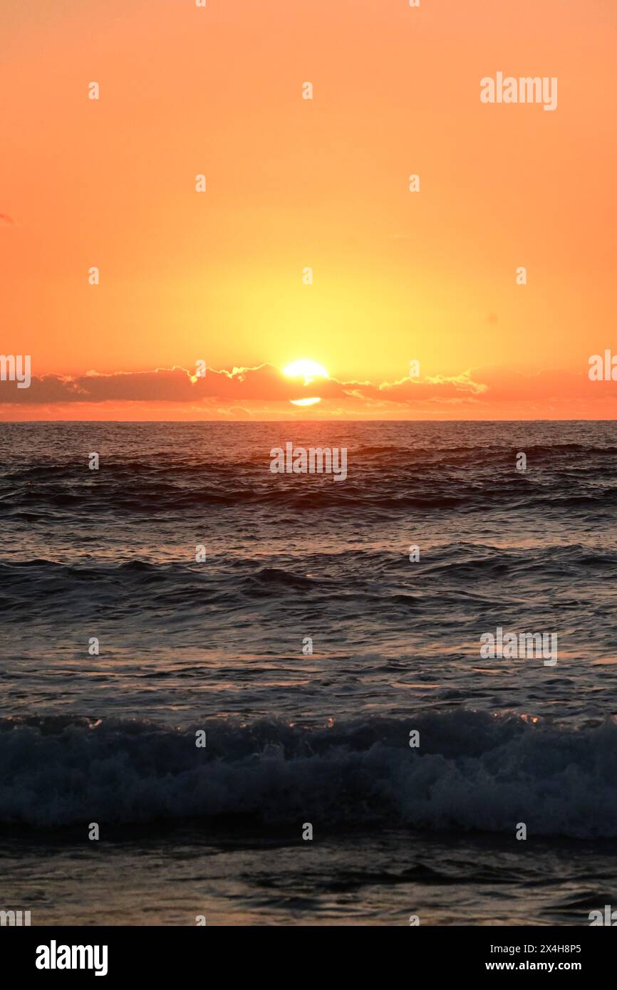 golden sunset casting a warm glow over the sea, with the sunlight ...