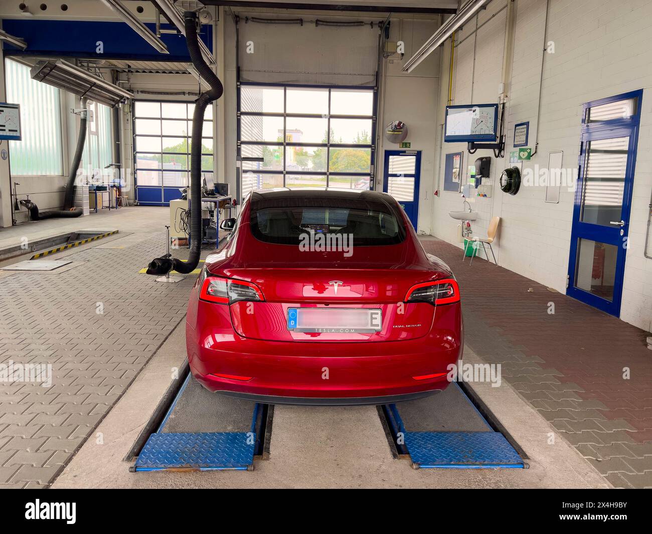 03-04-2024-ein-tesla-model-3-in-farbe-rot-in-der-werkstatt-amtliche