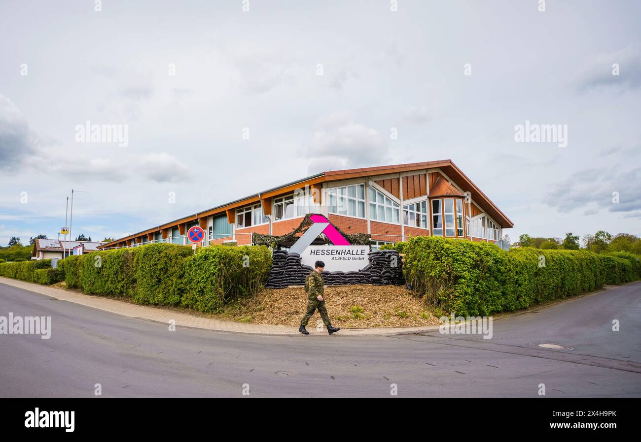 27 April 2024, Hesse, Alsfeld: A Bundeswehr soldier walks past the ...