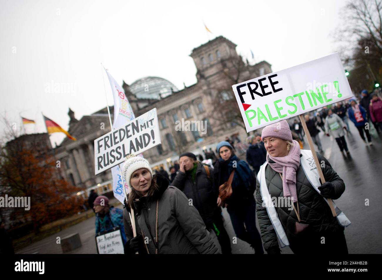 Friedensdemo Nein zu Kriegen DEU, Deutschland, Germany, Berlin, 25.11.2023 Demonstrant mit Schild Free Palestine in Solidaritaet zu Palaestina und Frieden mit Russland auf der Demonstration der deutschen Friedensbewegung unter dem Motto Nein zu Kriegen Ruestungswahnsinn stoppen Zukunft friedlich und gerecht gestalten Die Waffen nieder fuer Frieden und eine soziale Friedenspolitik am Brandenburger Tor in Berlin Deutschland . Der Protest fordert einen Waffenstillstand in Gaza , Friedensverhandlungen sowie Ende der Sanktionen gegen Russland , Ende der Waffenlieferungen an die Ukraine und allgemei Stock Photo