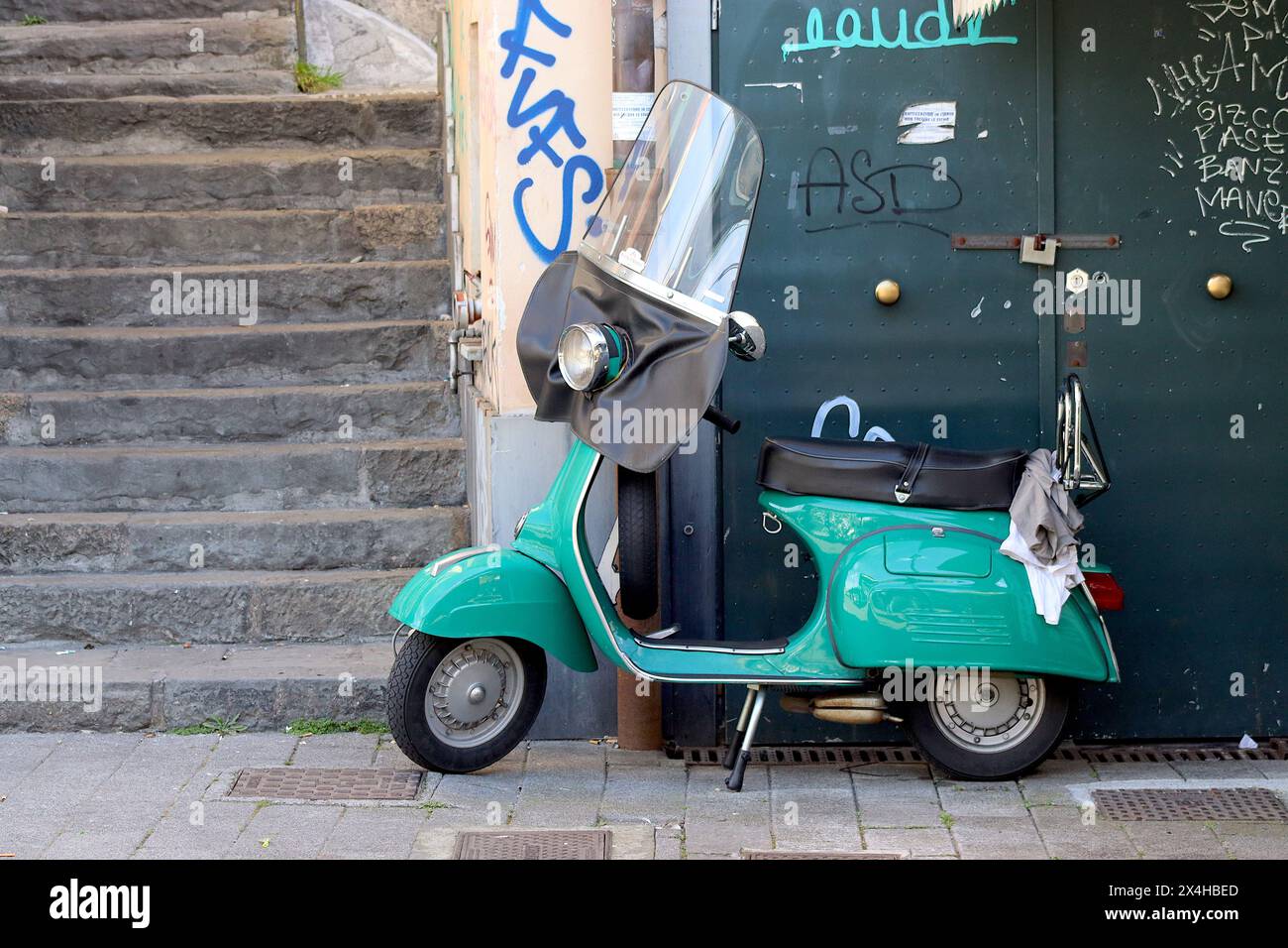 A totally restored Piaggio Vespa 150 Sprint Veloce scooter, with period windscreen, parked off road in the Italian port town of Genoa. Stock Photo