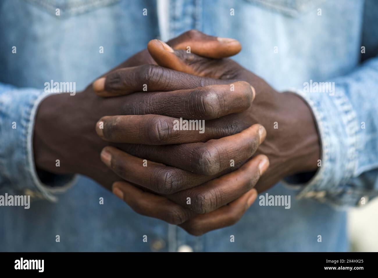 Folded hands of an African migrant, Bavaria, Germany Stock Photo