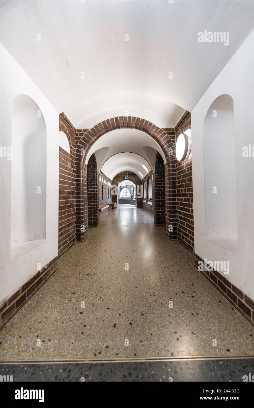 Elongated corridor in vaulted construction with brick walls and discreet lighting, Botanical Garden, Berlin, Germany Stock Photo