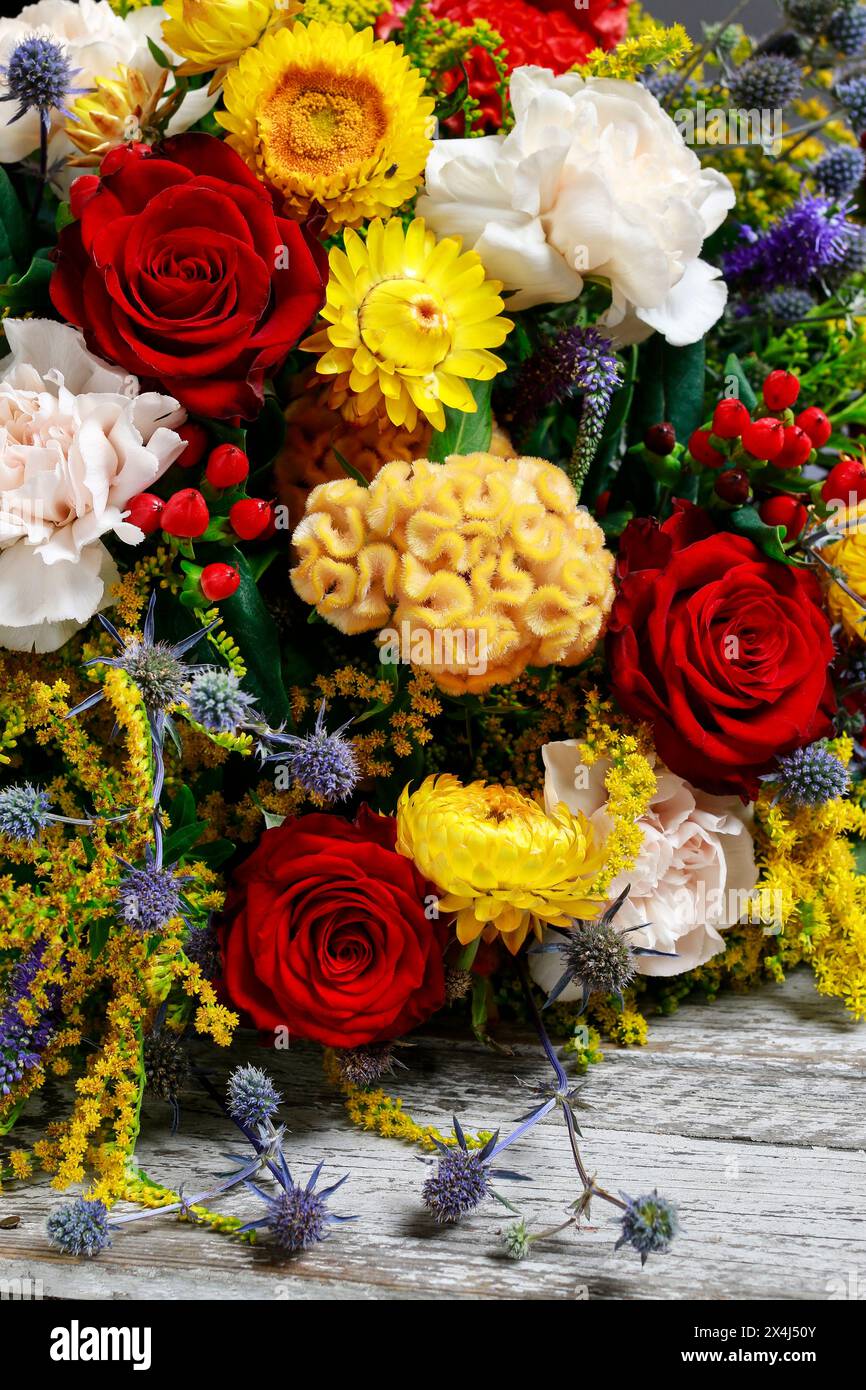 Bouquet of flowers with red roses, yellow celosias and white carnations. Party decor Stock Photo
