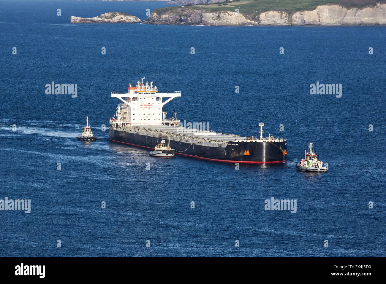 Vessel, GCL Dunkirk, solids bulk carrier, performing docking maneuvers at the Ingeniero León dock. Puerto del Musel, Gijón, Asturias, Spain Stock Photo