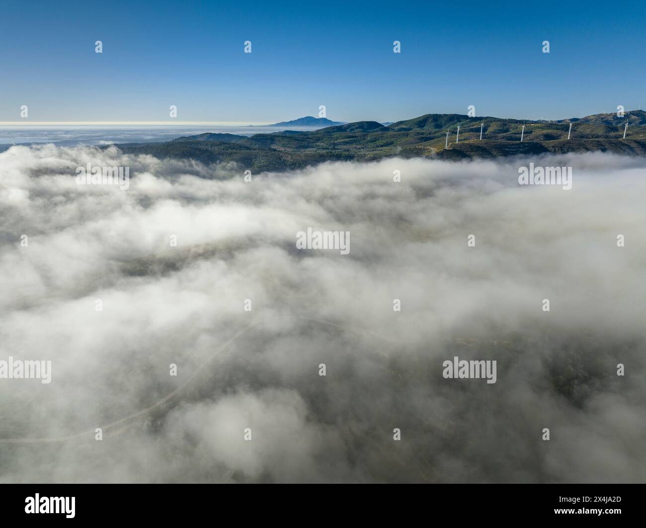 Aerial view of the Cardó - Boix mountain range on a winter morning with a sea of clouds and fog over the Pla de Burgar (Tarragona, Catalonia, Spain) Stock Photo