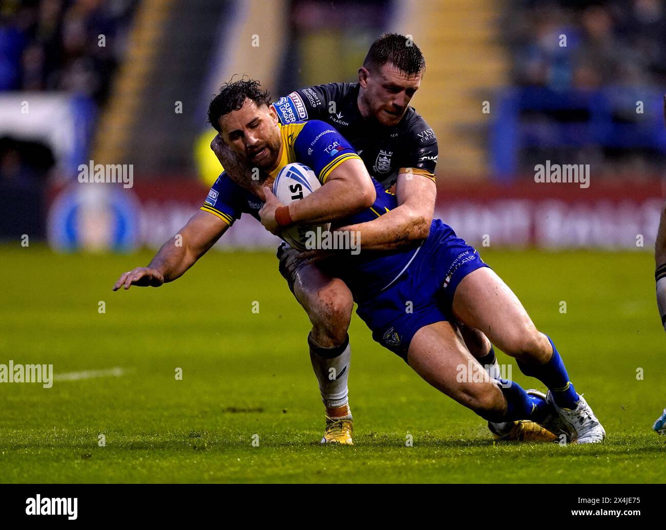 Warrington Wolves' Toby King is tackled by Hull FC's Ed Chamberlain during the Betfred Super League match at the Halliwell Jones Stadium, Warrington. Picture date: Friday May 3, 2024. Stock Photo