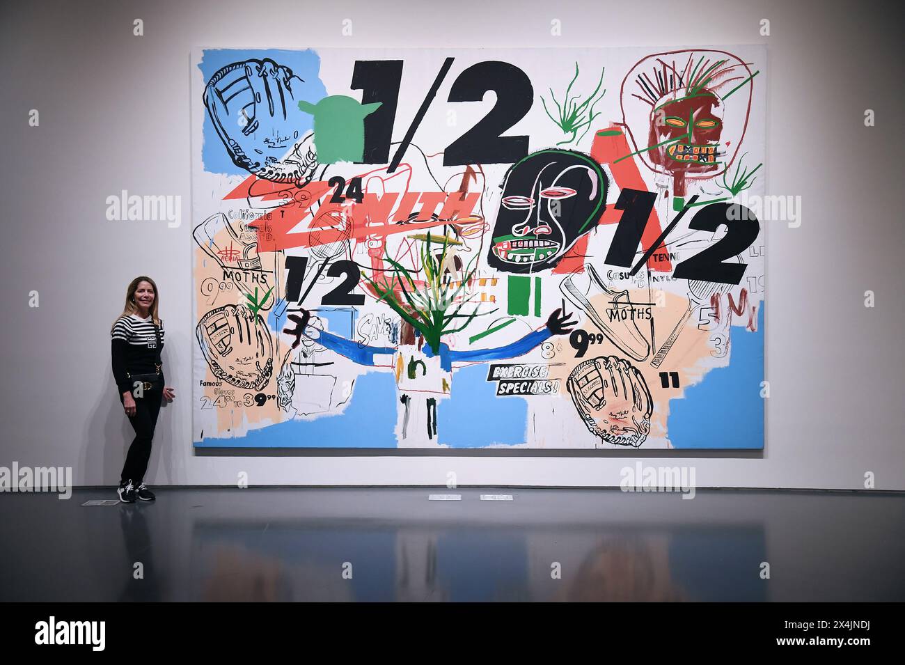 New York, USA. 03rd May, 2024. A visitor stands next to a collaborative painting between Andy Warhol and Jean-Michel Basquiat 'Untitled' estimated at $15M to $20M, on opening day of public exhibitions for Sotheby's marquee contemporary and Modern art auctions, New York, NY, May 3, 2024. (Photo by Anthony Behar/Sipa USA) Credit: Sipa USA/Alamy Live News Stock Photo
