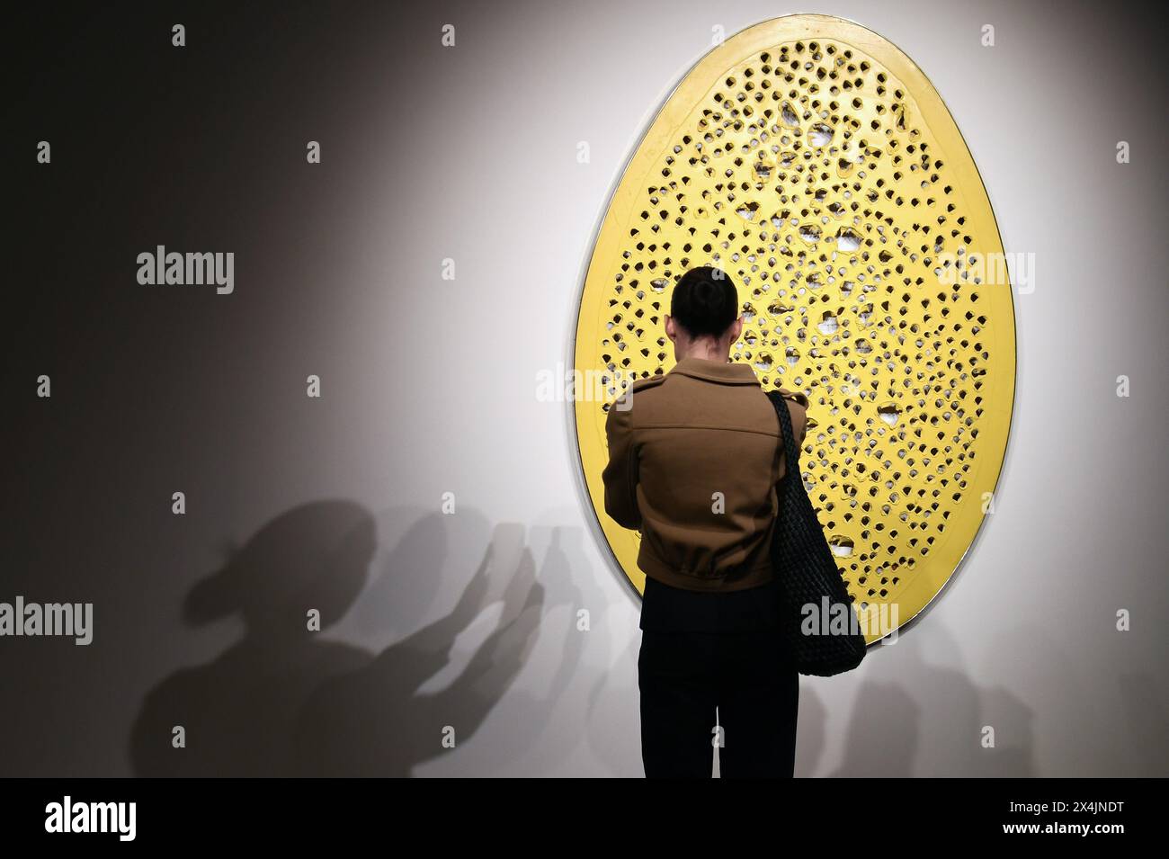 New York, USA. 03rd May, 2024. A visitor photographs an art piece by Lucio Fontana titled 'Concerto spatial, La fine di Din' on opening day of public exhibitions for Sotheby's marquee contemporary and Modern art auctions, New York, NY, May 3, 2024. (Photo by Anthony Behar/Sipa USA) Credit: Sipa USA/Alamy Live News Stock Photo