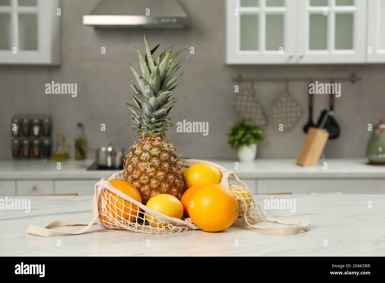 String bag with fresh fruits on light table in kitchen Stock Photo