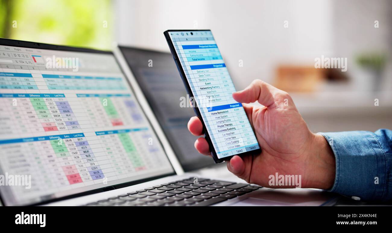 Man Using Spreadsheet Data On Laptop Computer Stock Photo