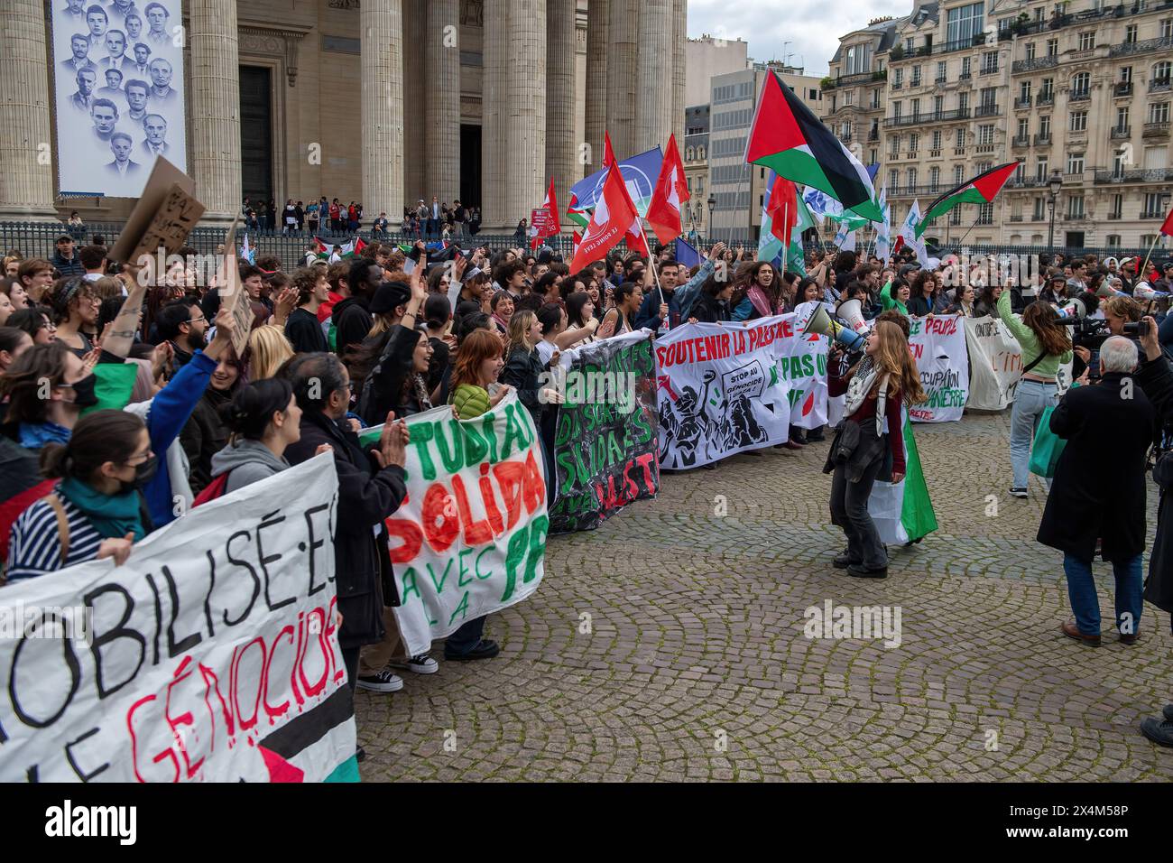 Students wave flags, hold banners and chant slogans in the shadow of ...