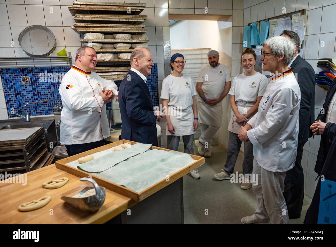 Berlin, Germany. 29th Apr, 2024. Federal Chancellor Olaf Scholz (SPD, 2nd from left) talks to baker and owner of the SoLuna bakery Christa Lutum (r) and employees during a visit to the SoLuna bakery in Berlin Credit: Odd Andersen/POOL AFP/dpa/Alamy Live News Stock Photo