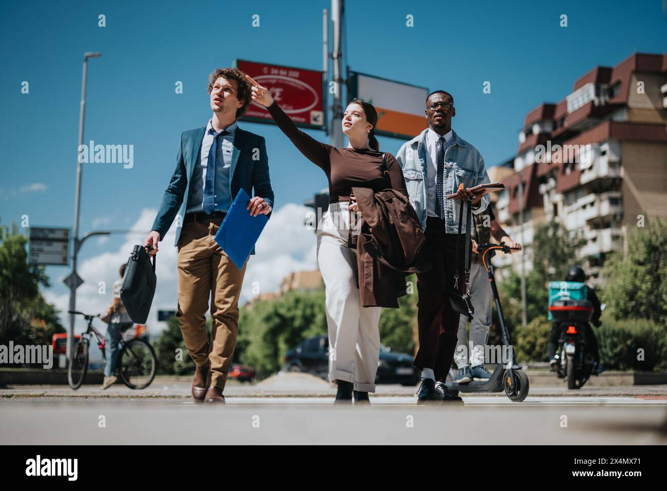 Diverse business team walking outdoors on a sunny city day, brainstorming ideas Stock Photo
