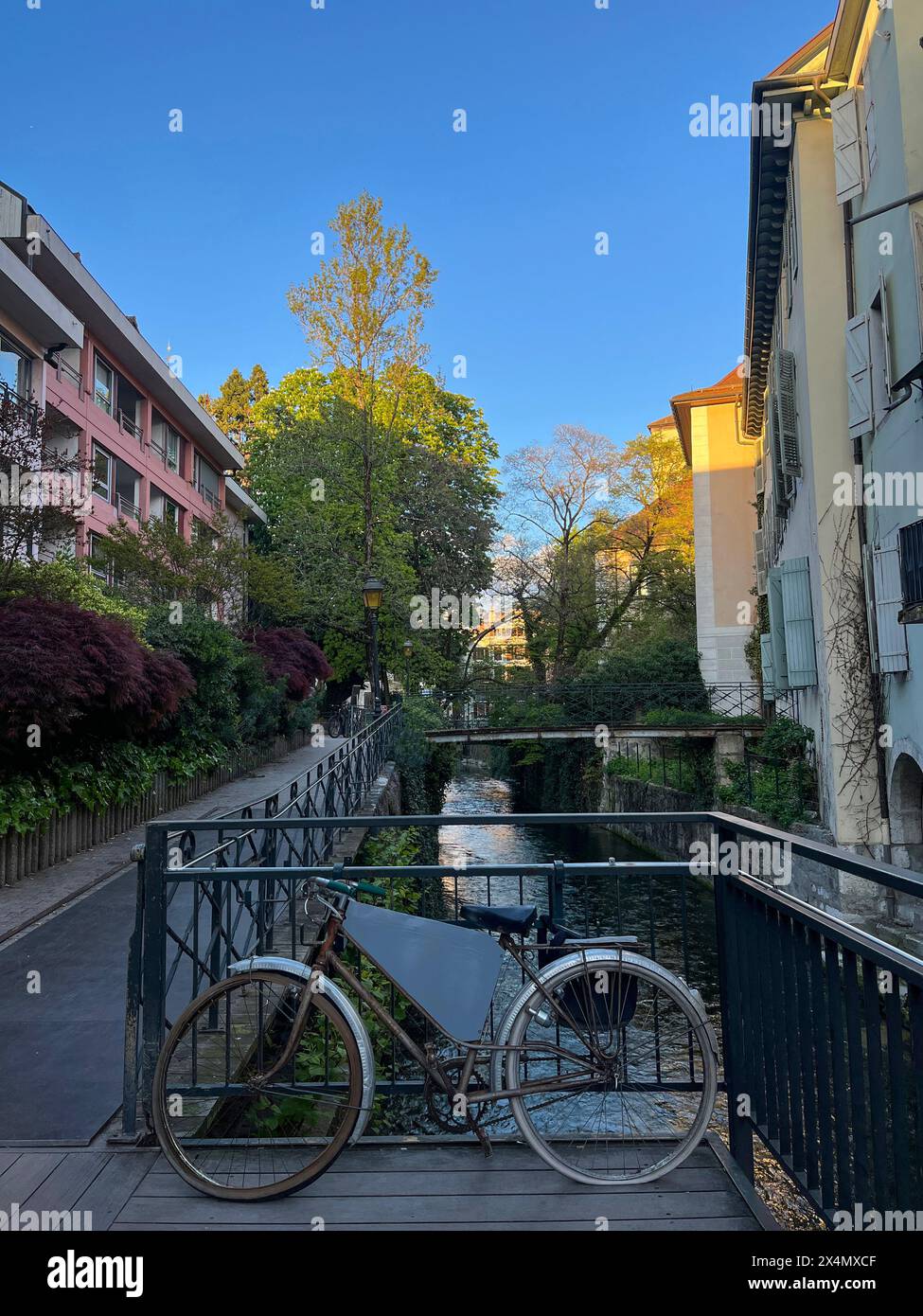Annecy, Haute-Savoie, France: a bicycle parked on a railing along one of the canals of the Thiou River that made Annecy famous as the French Venice Stock Photo