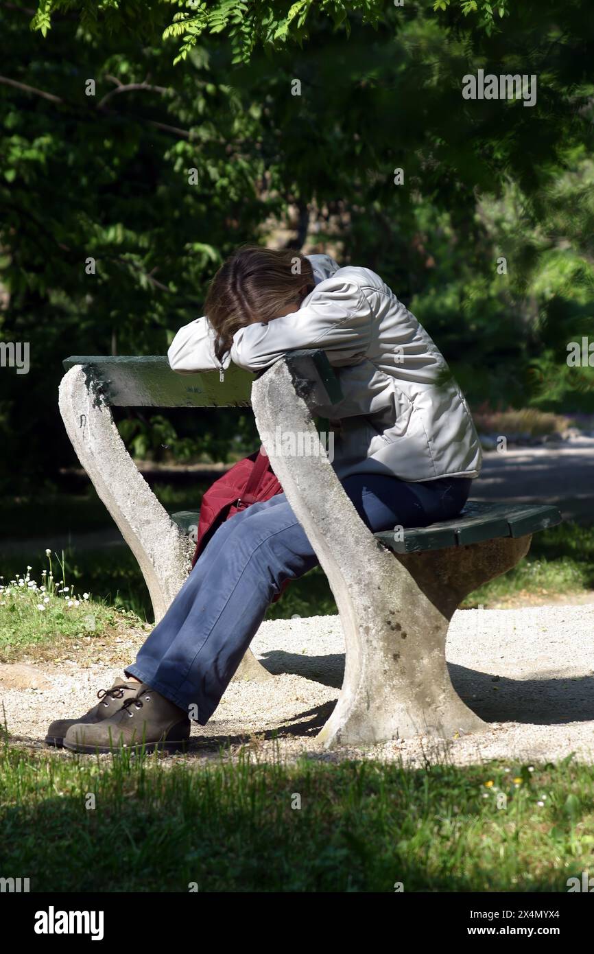 Depressed girl sitting in the park in Zagreb, Croatia Stock Photo