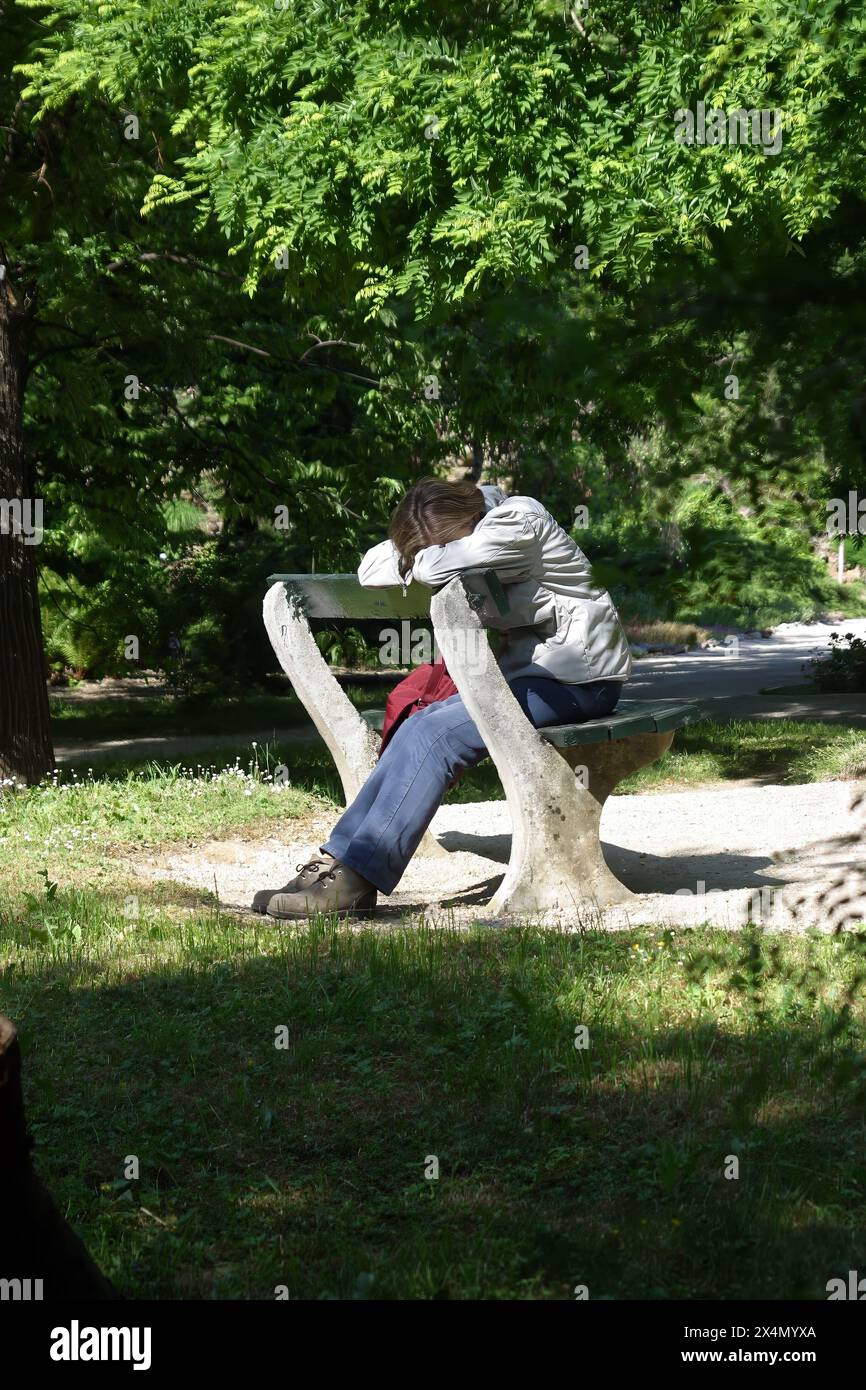 Depressed girl sitting in the park in Zagreb, Croatia Stock Photo