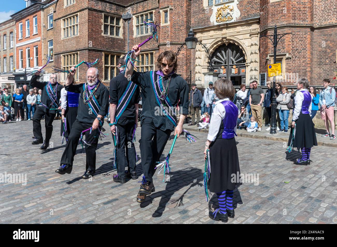 May 4th 2024. The Guildford Summerpole Festival took place in the town centre today. The annual event run by the Guildford Pilgrim Morris dancers involves a procession up the High Street, displays of morris dancing by several groups, followed by erecting the summerpole (instead of a traditional maypole) in Guildford Castle grounds, and further dancing. Customs and Exiles North West Morris dance team from Wokingham dancing outside Abbot's Hospital. Stock Photo