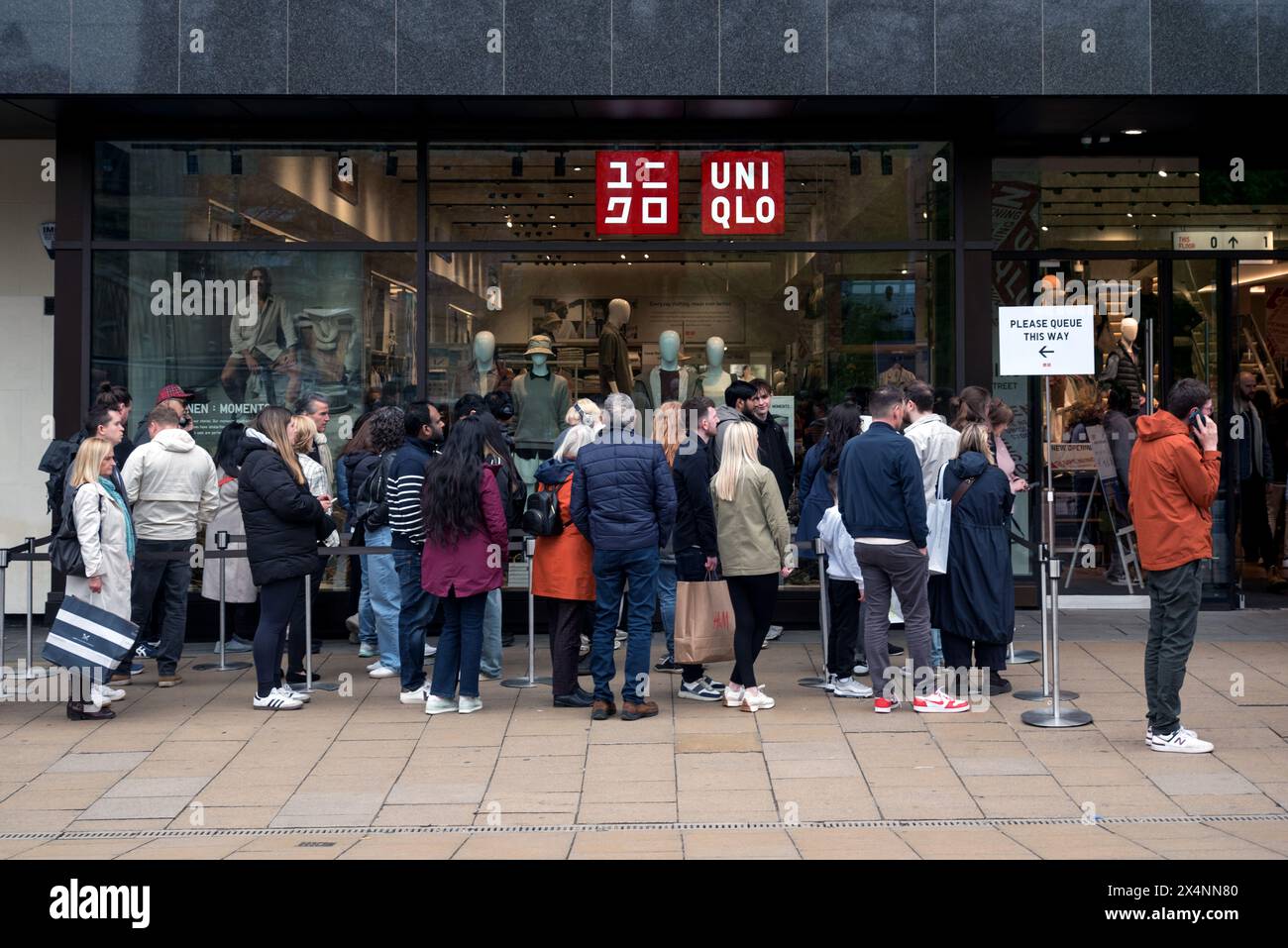 Shoppers queue in line outside japanese fashion retailer uniqlo on