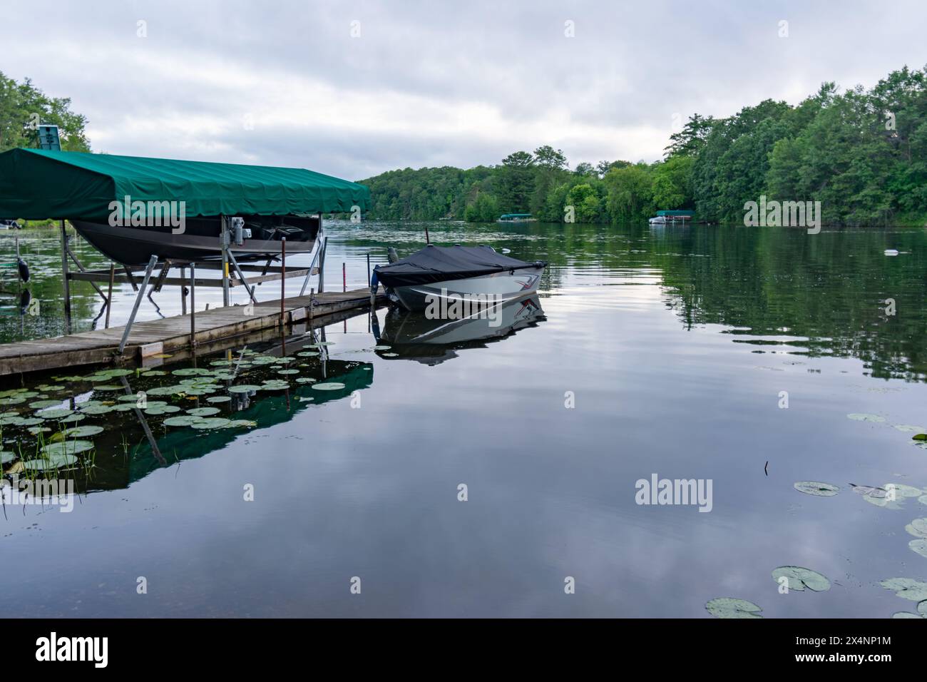 Looking out onto a northern Wisconsin lake in the evening with boats moored for the evening. Stock Photo