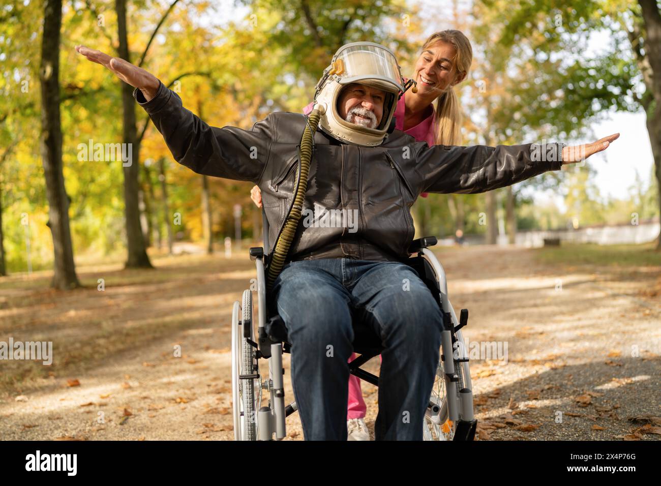 Elderly man in astronaut helmet and leather jacket joyfully extends ...