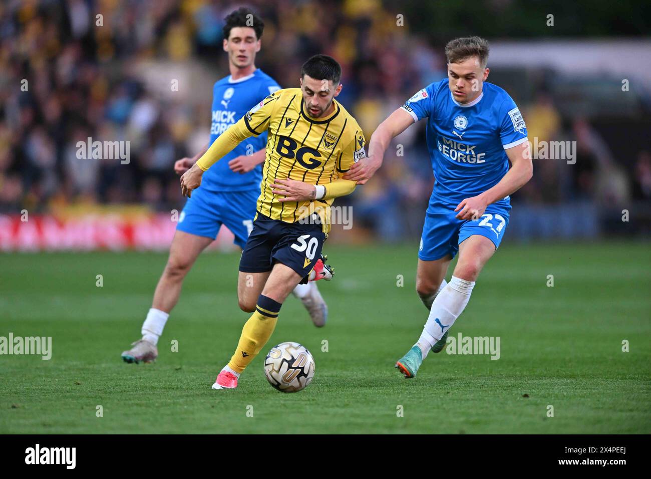 Owen Dale (30 Oxford United) challenged by Archie Collins (27