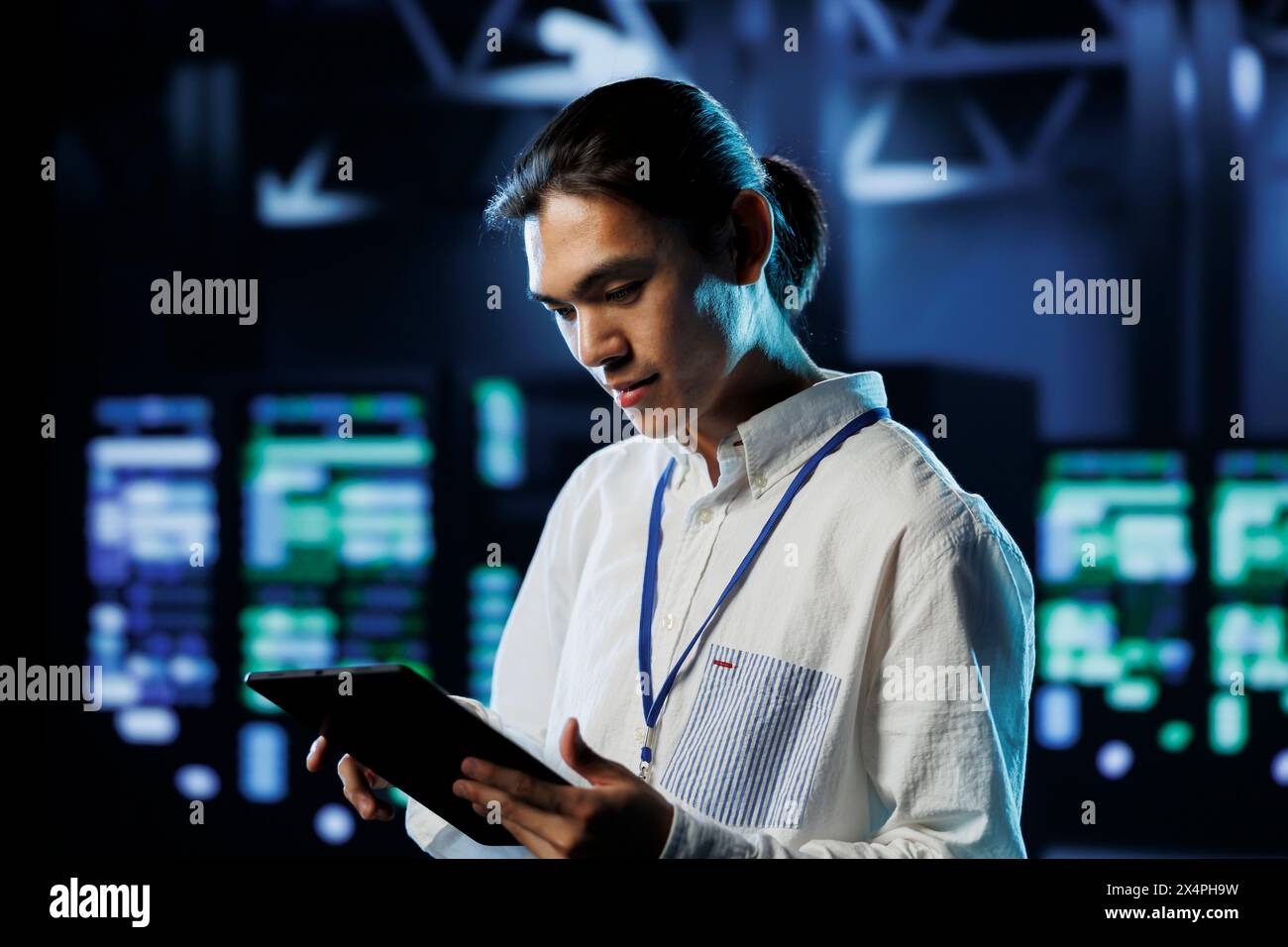 Knowledgeable developer between server hub clusters providing processing resources for businesses worldwide. Skilled employee fixes data center mainframes tasked with managing massive databases Stock Photo