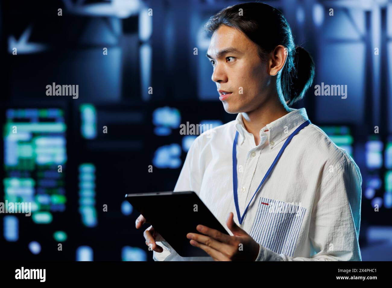 IT consultant with tablet between server hub clusters providing processing resources for businesses worldwide. Diligent worker fixes data center mainframes tasked with managing massive databases Stock Photo