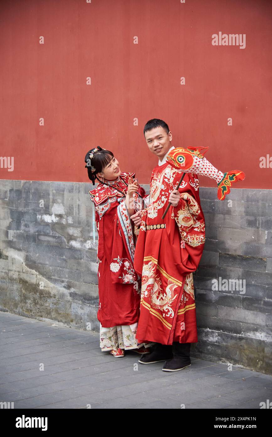 Cute Chinese wedding couple posing outdoors in old hutong street in Beijing, China on 19 April 2024 Stock Photo