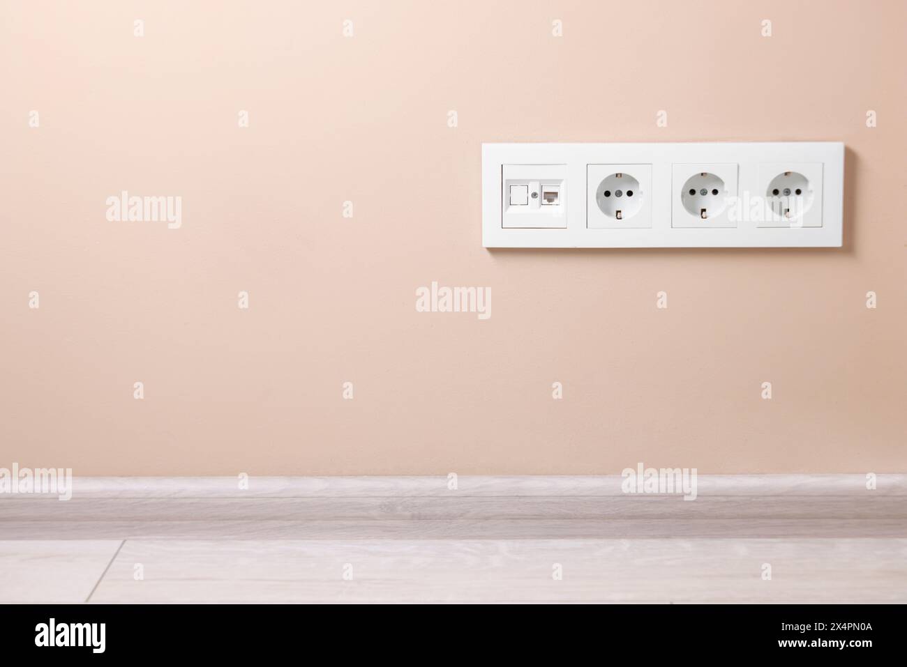 Electric power sockets on beige wall, space for text Stock Photo - Alamy