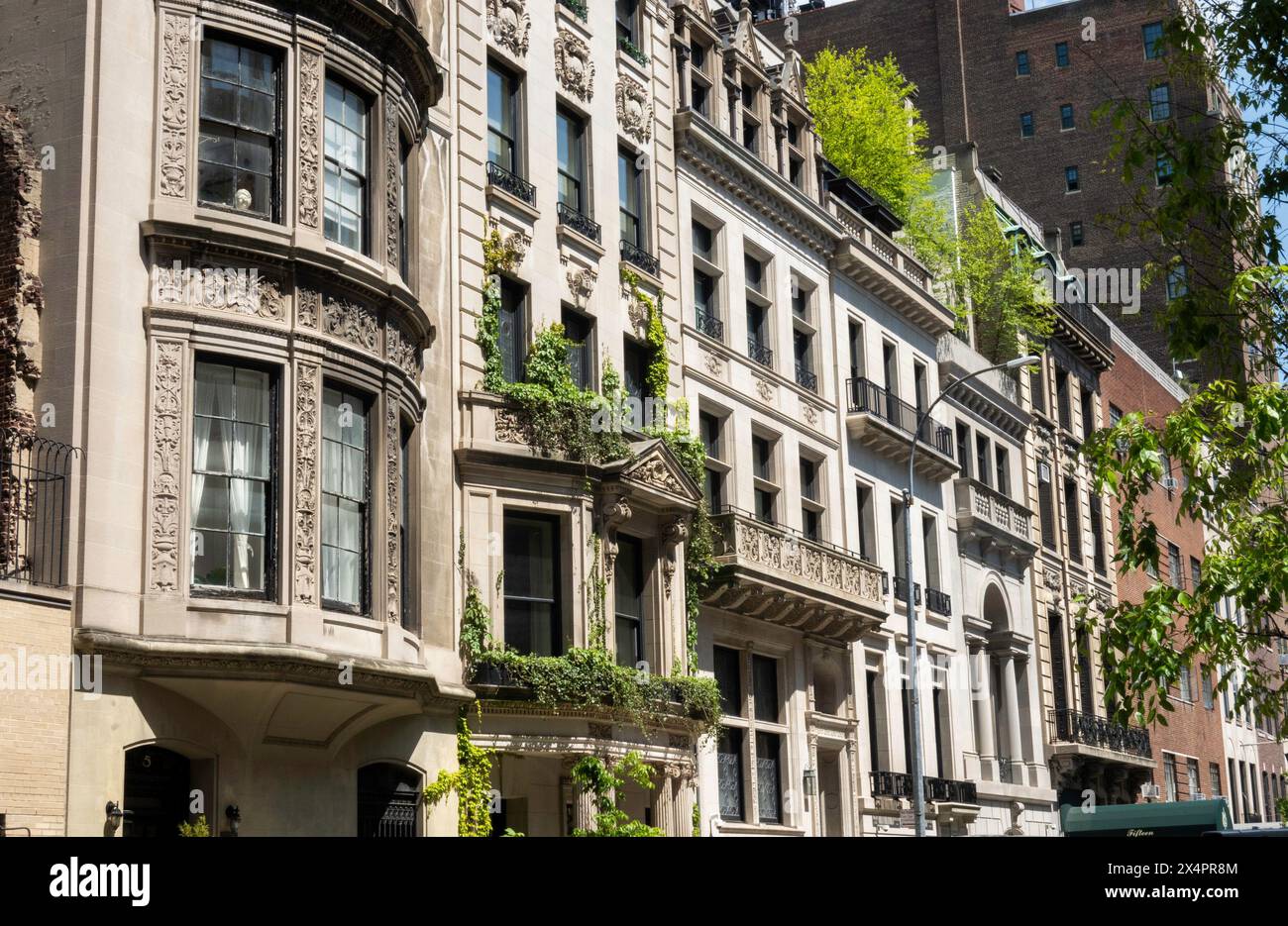 Luxury homes along E. 67th St. in the Upper Eastside Historic District on a sunny spring afternoon, 2024, New York City, USA Stock Photo