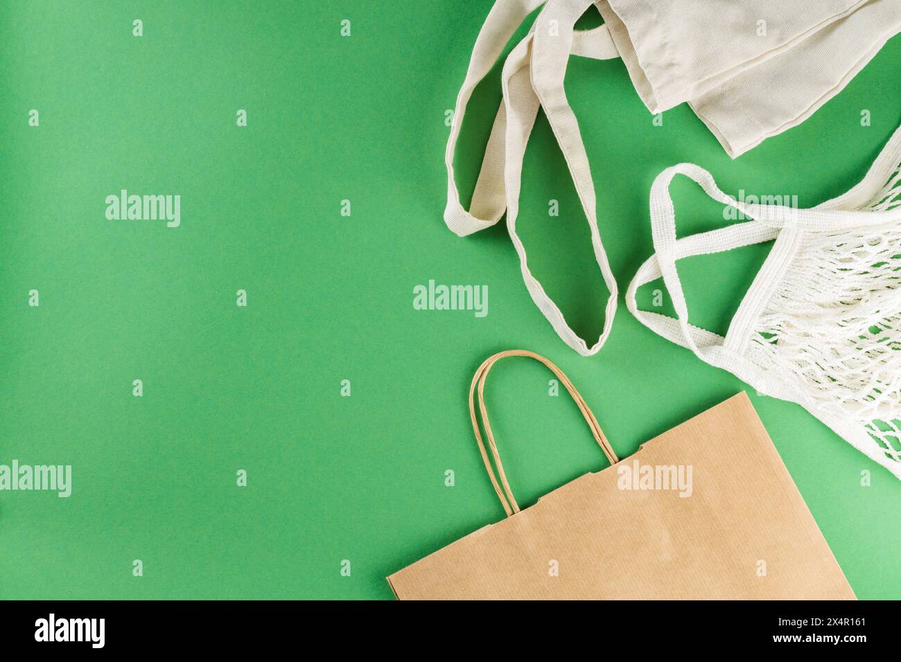 Cotton and Paper Bags on Green Background, Sustainable Zero Waste Lifestyle Concept Stock Photo