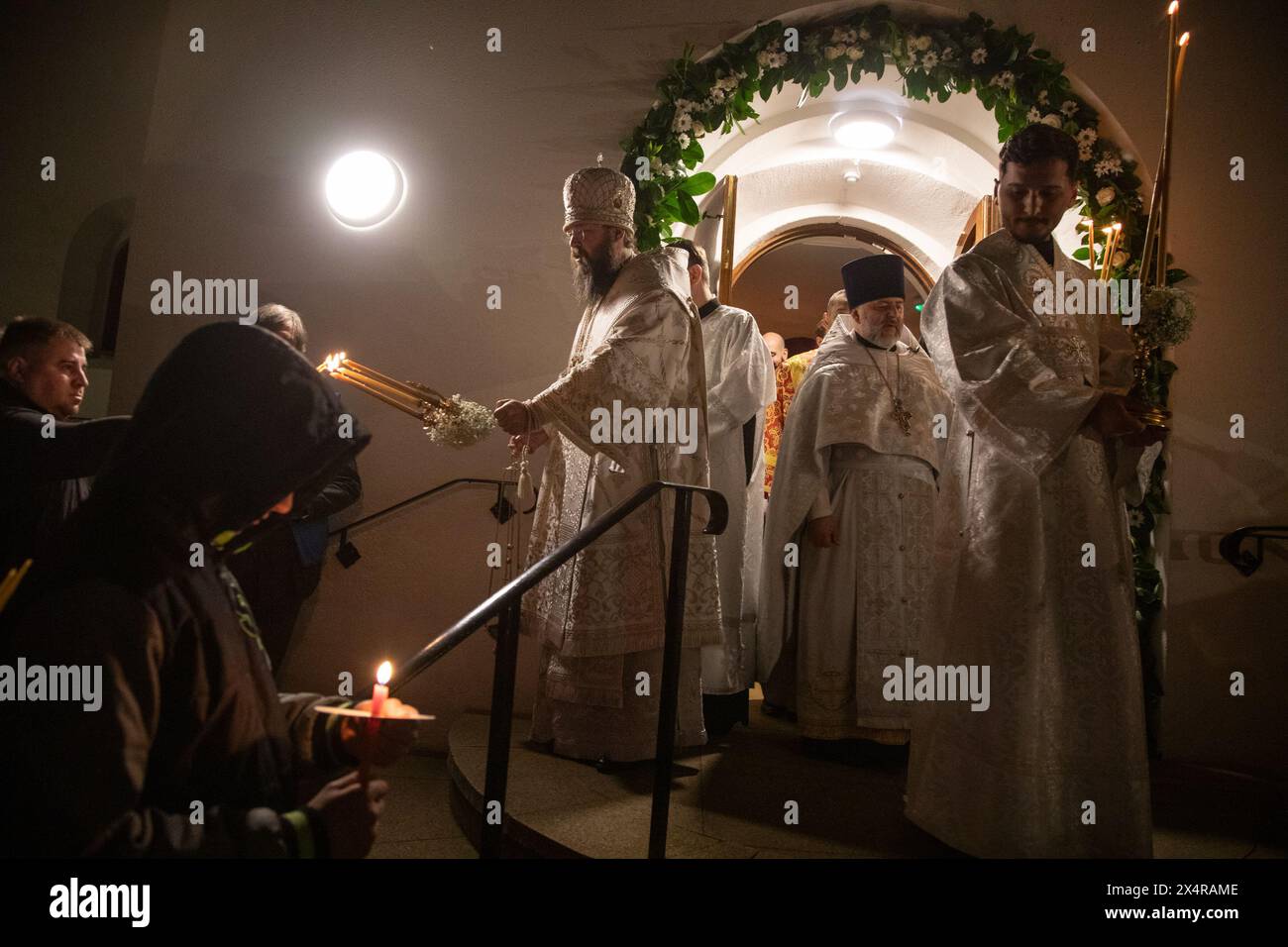 London, UK. 5th May 2024.Bishop Irenei lights worshippers' candles during  an Easter midnight service at the Russian Orthodox Cathedral of the Nativity of the Most Holy Mother of God and the Holy Royal Martyrs in West London. Credit: Kiki Streitberger/Alamy Live News Stock Photo