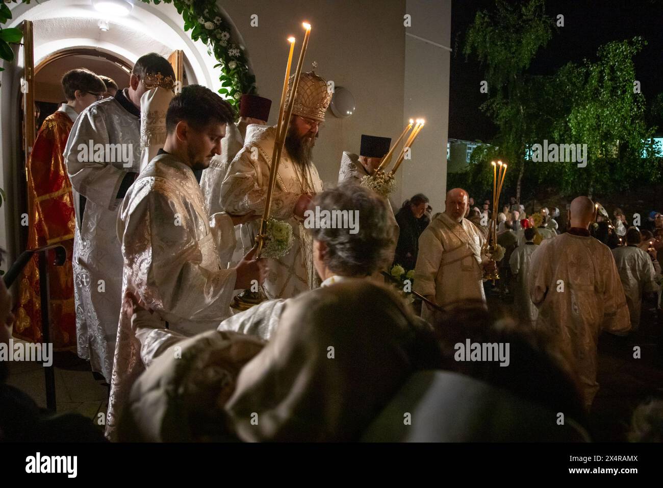London, UK. 5th May 2024.Bishop Irenei lights worshippers' candles during  an Easter midnight service at the Russian Orthodox Cathedral of the Nativity of the Most Holy Mother of God and the Holy Royal Martyrs in West London. Credit: Kiki Streitberger/Alamy Live News Stock Photo