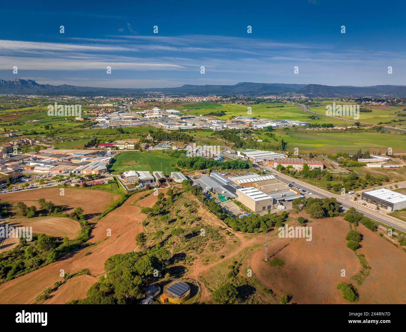 Aerial view of industrial estates and green fields in Pla de Bages on a spring morning (Barcelona, Catalonia, Spain) Stock Photo
