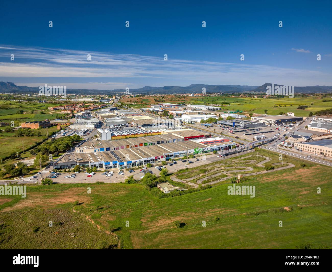 Aerial view of industrial estates and green fields in Pla de Bages on a spring morning (Barcelona, Catalonia, Spain) Stock Photo