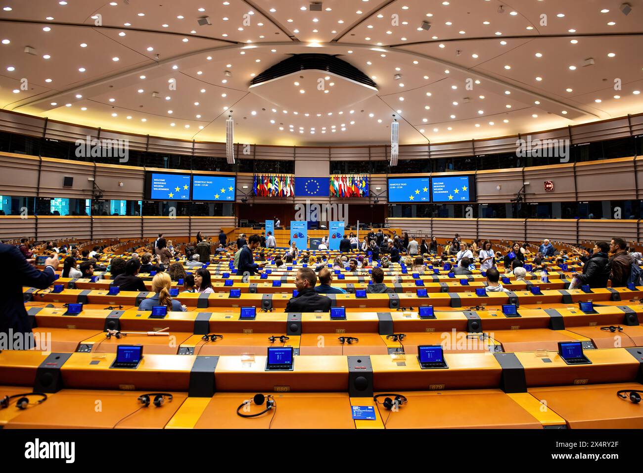 The public get to walk around and sit in the EU parliament chamber during an open day to celebrate the birthday of the European Parliament in Brussels. Celebrating the European Parliament's birthday in Brussels, visitors gained special access to the Parliament chambers and the iconic building itself. The open day featured informative stands on the upcoming European Parliament elections, fostering political engagement and dialogue. Against the backdrop of European democracy, attendees immersed themselves in the legislative process, symbolizing transparency and civic participation. The event sh Stock Photo