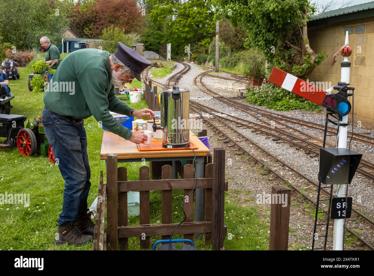 A volunteer makes a cup of tea from a hot water urn at South Downs Light Railway, Pulborough, UK Stock Photo