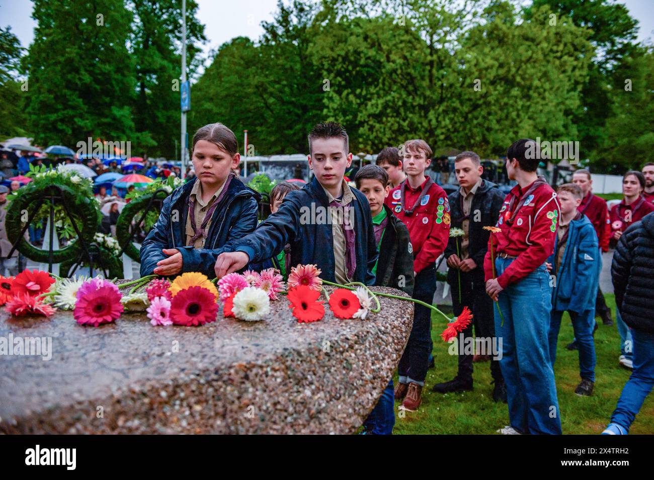 Nijmegen, Netherlands. 04th May, 2024. Boy scouts are seen leaving flowers at the end of the ceremony. On this day, the whole country commemorates civilians and soldiers during the World War II and other conflicts. In Nijmegen, a silent procession took the streets to the 'Keizer Traianusplein', where two monuments in remembrance of the victims of WWII stand up. The official ceremony started with two minutes of silence, and wreaths were laid. (Photo by Ana Fernandez/SOPA Images/Sipa USA) Credit: Sipa USA/Alamy Live News Stock Photo