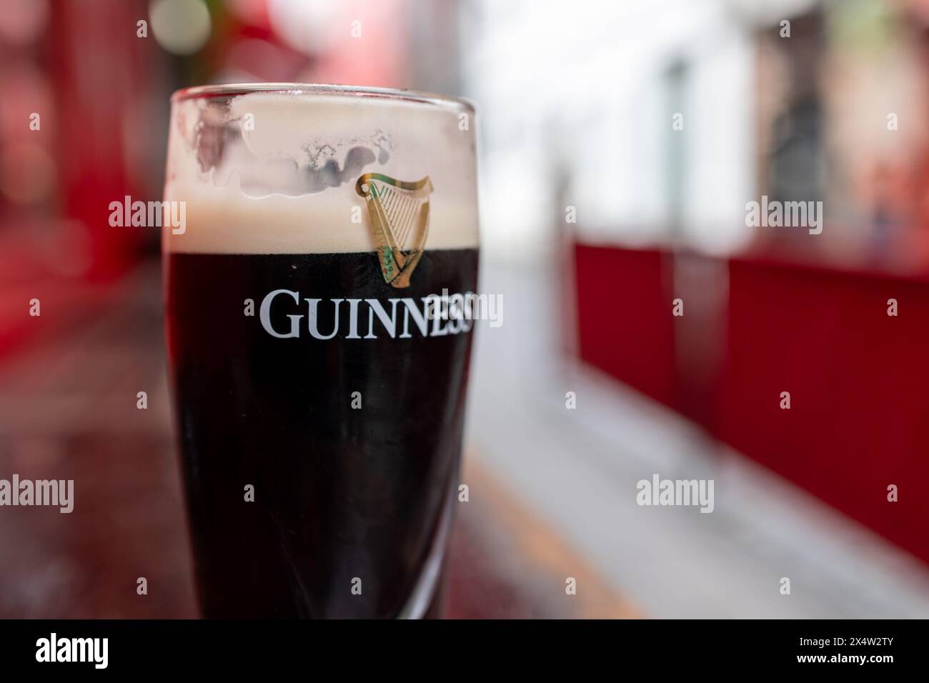 DUBLIN, IRELAND - 26 MARCH 2023: A pint glass of Guinness beer rests on a table. Stock Photo