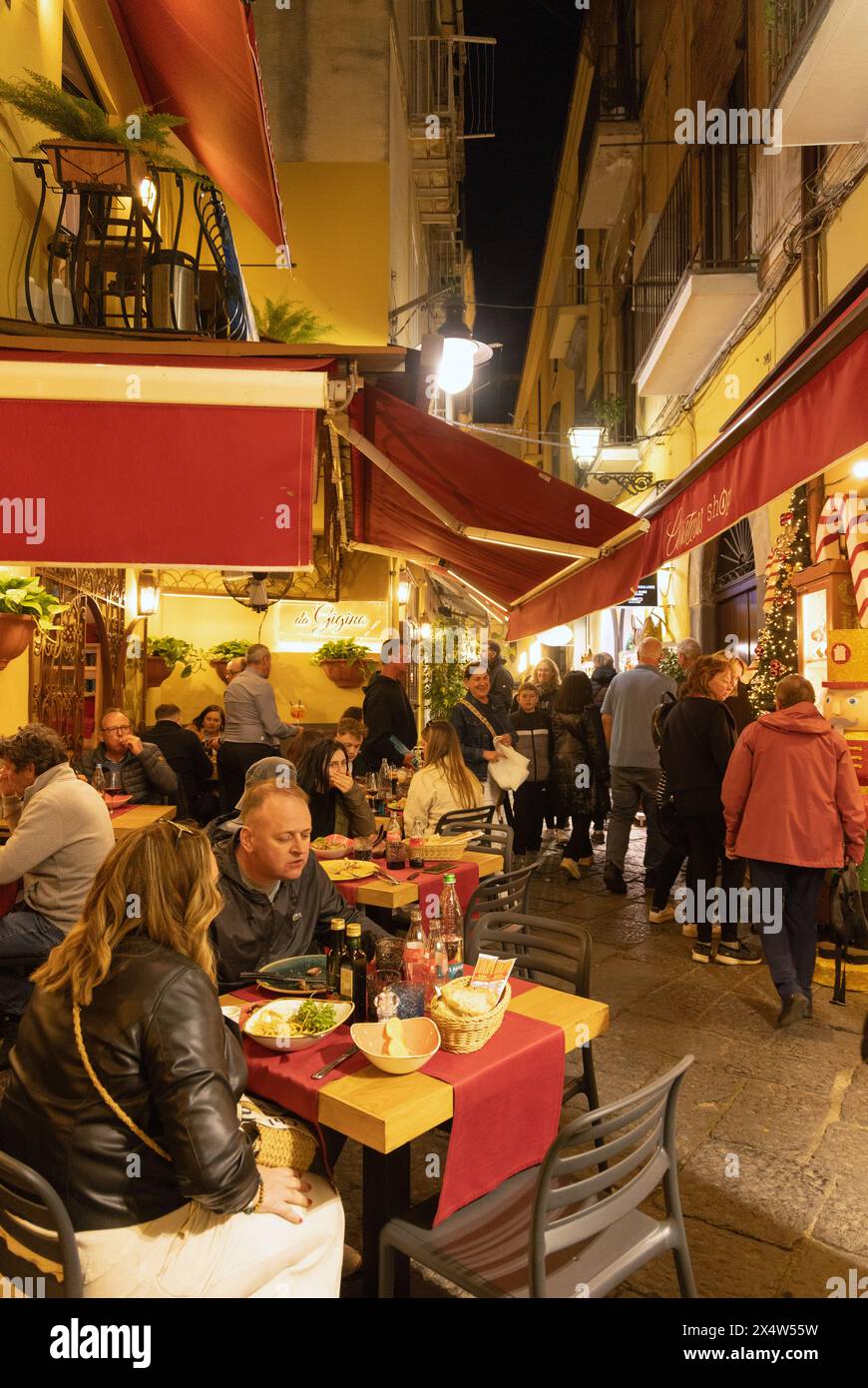 Sorrento night scene - people eating al fresco in a restaurant on a narrow Sorrento street, Sorrento Italy Europe Stock Photo