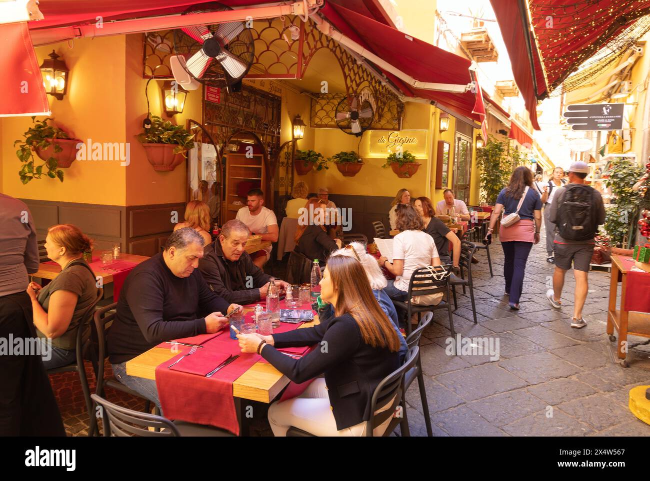 Sorrento restaurant - people eating outside at a restaurant in a narrow street in Sorrento in summer, Sorrento Campania Italy. Italy restaurant. Stock Photo