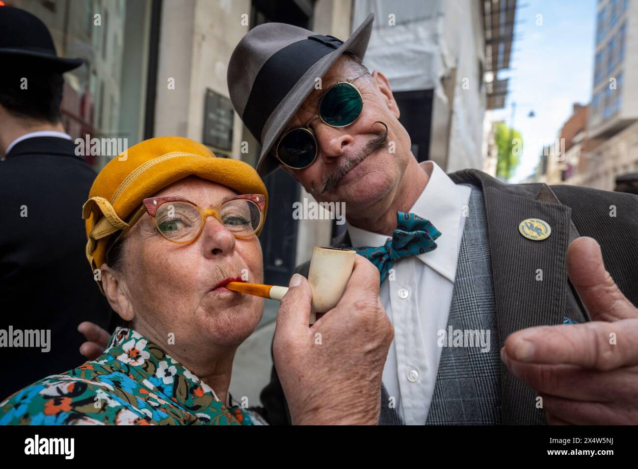 London, UK.  5 May 2024.  Elegantly dressed people, with a traditional pipe, take part in the fourth Grand Flâneur walk. Starting at the Beau Brummell statue on Jermyn Street, the walk coincides with the 25th anniversary of The Chap magazine and is defined as a walk without purpose, celebrating the art of the flâneur, oblivious to going anywhere specific, and an antidote to the demands of modern life and the digital smartphone.  Credit: Stephen Chung / Alamy Live News Stock Photo