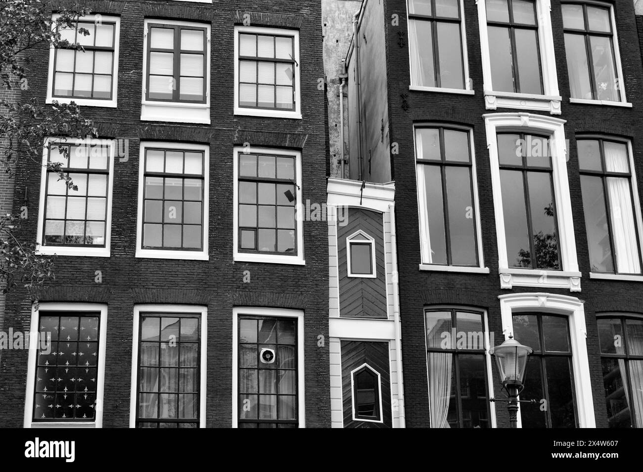Holland, Amsterdam, the facade of old private stone houses downtown, the central one is the smallest house in the city Stock Photo