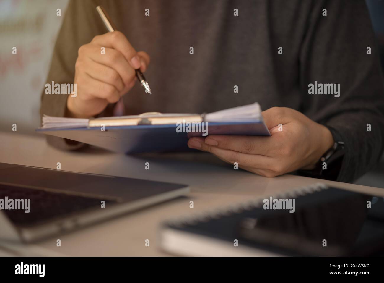 man holding clipboard with checklist employee workplace is reviewing documents Stock Photo